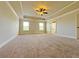 Spacious main bedroom with tray ceiling, carpet, and natural light from windows at 1264 Brynhill Ct, Buford, GA 30518