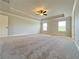 Spacious main bedroom featuring neutral tones, tray ceiling, ceiling fan, and two windows for natural light at 1264 Brynhill Ct, Buford, GA 30518