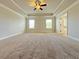 Main bedroom showcasing natural light, tray ceilings, carpet, and a fan at 1264 Brynhill Ct, Buford, GA 30518
