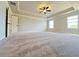 Bright main bedroom with plush carpet, a ceiling fan, and two large windows providing natural light at 1264 Brynhill Ct, Buford, GA 30518