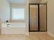 Bathroom featuring tiled soaking tub and glass enclosed shower with tiled surround at 1264 Brynhill Ct, Buford, GA 30518