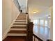Staircase featuring hardwood steps and decorative metal railings, with a view of the living room at 1264 Brynhill Ct, Buford, GA 30518