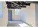 Unfinished basement with exposed ceiling, a window, and gray door for easy access at 4011 Lake Carlton Rd, Loganville, GA 30052
