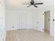 Bright bedroom with hardwood floors, ceiling fan, and closet with doors at 4011 Lake Carlton Rd, Loganville, GA 30052