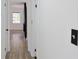 Hallway with wood floors leading into a room with a window and a black fireplace at 4011 Lake Carlton Rd, Loganville, GA 30052
