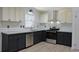 Modern kitchen featuring gray lower cabinets, white upper cabinets, and stainless steel appliances at 4011 Lake Carlton Rd, Loganville, GA 30052