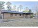 Rear view of the brick home showing a covered back porch and backyard at 4011 Lake Carlton Rd, Loganville, GA 30052