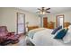 Bedroom with wood floors, ceiling fan, large window and comfortable red lounge chair at 4030 Grady Smith Road Rd, Loganville, GA 30052