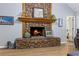 Close-up of stone fireplace with wooden mantel, burning logs, and hardwood floors at 4030 Grady Smith Road Rd, Loganville, GA 30052