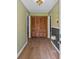 Inviting foyer featuring hardwood floors, wooden closet doors, and a stylish ceiling light fixture at 4030 Grady Smith Road Rd, Loganville, GA 30052