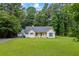 Quaint single-Gathering home with a lush green lawn, accompanied by a detached garage and inviting entrance at 4030 Grady Smith Road Rd, Loganville, GA 30052