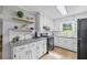 Charming kitchen with white cabinets, granite counters, and floating wood shelves at 4030 Grady Smith Road Rd, Loganville, GA 30052