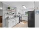 Well-lit kitchen boasts white cabinets, granite countertops, and black appliances at 4030 Grady Smith Road Rd, Loganville, GA 30052