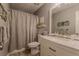 Well-maintained bathroom features a tub with shower curtain and decorative mirror and shelf at 5176 Ashbury Manor Ln, Sugar Hill, GA 30518