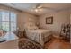 Cozy bedroom featuring a ceiling fan, a window with natural light, and wood flooring at 5176 Ashbury Manor Ln, Sugar Hill, GA 30518