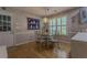 Cozy dining area features hardwood floors and a glass table near a sunny window at 5176 Ashbury Manor Ln, Sugar Hill, GA 30518
