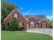 Inviting red brick home with lush green lawn, black shutters, and a classic, well-maintained appearance at 5176 Ashbury Manor Ln, Sugar Hill, GA 30518