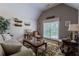 Cozy living room featuring neutral decor, a vaulted ceiling, and a large window providing natural light at 5176 Ashbury Manor Ln, Sugar Hill, GA 30518