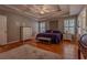 Bright main bedroom showcases hardwood floors, tray ceiling, and dual windows, complemented by neutral decor at 5176 Ashbury Manor Ln, Sugar Hill, GA 30518