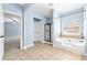 Spacious bathroom with a soaking tub, separate shower, and tile flooring leading to bedroom at 5430 Breckinridge Ln, Cumming, GA 30040