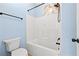 Well-lit bathroom featuring a shower and tub combination with marble accent wall at 5430 Breckinridge Ln, Cumming, GA 30040