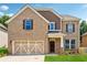 Inviting two-story brick home with a two-car garage and manicured lawn at 5430 Breckinridge Ln, Cumming, GA 30040