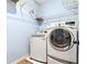 Laundry room with washer, dryer, and overhead shelving for storage at 5430 Breckinridge Ln, Cumming, GA 30040
