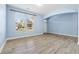 Well-lit living room with hardwood floors, large windows, and an arched entryway at 5430 Breckinridge Ln, Cumming, GA 30040