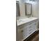 Bathroom with a white vanity, dual sinks, and framed mirrors at 188 Rue Fontaine, Lithonia, GA 30038