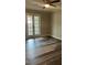 Bedroom with patio access featuring a ceiling fan and newly installed wood flooring at 188 Rue Fontaine, Lithonia, GA 30038