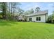 Lush backyard offers ample green space, complemented by a covered patio, and verdant trees for shade at 5015 Monticello Dr, Villa Rica, GA 30180