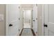 Hallway with white paneled doors, tan walls, and a view into the laundry room with white marble floors at 5015 Monticello Dr, Villa Rica, GA 30180