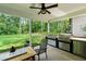 Covered outdoor kitchen with stainless steel grill and cabinets overlooking the lawn and surrounding trees at 5015 Monticello Dr, Villa Rica, GA 30180