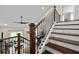 View of the staircase featuring dark wood treads, black metal railings, and a view into the adjacent living area at 5015 Monticello Dr, Villa Rica, GA 30180