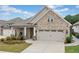 Charming brick home featuring a two-car garage, manicured landscaping, and covered porch entry at 205 Floral Valley Dr, Woodstock, GA 30188