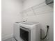 Bright laundry area with gray tile floor, wire rack shelving, and new washer and dryer at 205 Floral Valley Dr, Woodstock, GA 30188