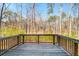 Enjoy the tranquility of the backyard's wooded view from a wooden deck and railing at 2536 Dayview Ln, Atlanta, GA 30331