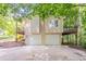 Unique house with a two-car garage and upper deck, surrounded by trees and lush greenery at 356 Waterway Trl, Powder Springs, GA 30127