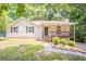 Inviting single-story home featuring a charming front porch, well-maintained lawn, and surrounded by lush trees at 356 Waterway Trl, Powder Springs, GA 30127