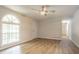 Living room featuring new flooring, neutral paint, a ceiling fan, and a large arched window at 356 Waterway Trl, Powder Springs, GA 30127