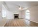 Bright living room with stone fireplace, light wood floors, ceiling fan, and a large arched window at 356 Waterway Trl, Powder Springs, GA 30127