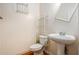 Compact half bathroom featuring a pedestal sink, toilet and storage at 485 Greyhawk Way, Fairburn, GA 30213