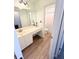 Well-lit bathroom with a single vanity, a large mirror, and a peek into the shower at 5625 Jamerson Dr, Atlanta, GA 30349