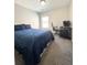 Comfortable bedroom with blue bedding and a workspace with a desk and rolling chair at 5625 Jamerson Dr, Atlanta, GA 30349