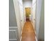 Hallway featuring hardwood flooring and a view of a laundry area, providing a practical and tidy space at 5625 Jamerson Dr, Atlanta, GA 30349