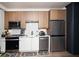 Efficient kitchen featuring stainless steel appliances, wood-tone cabinets, and white countertops, with modern fixtures at 108 Park Pl # 108, Atlanta, GA 30030