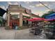 Cozy outdoor patio with cafe umbrellas, seating, and vibrant signage at Mojo Pizza at 108 Park Pl # 108, Atlanta, GA 30030