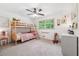 A cozy bedroom with a bunk bed, a ceiling fan, and natural light from the window at 2220 Williams Ln, Cumming, GA 30028