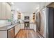 Well-lit kitchen featuring stainless steel appliances, dark countertops, bright white cabinets, and wood flooring at 2220 Williams Ln, Cumming, GA 30028