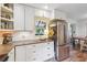 Kitchen featuring white cabinets, stainless steel appliances, and an open view to the dining area at 2220 Williams Ln, Cumming, GA 30028